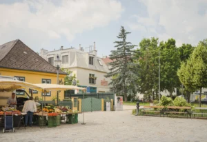 Der historische Maurer Hauptplatz in Wien mit belebten Straßencafés und Geschäften.